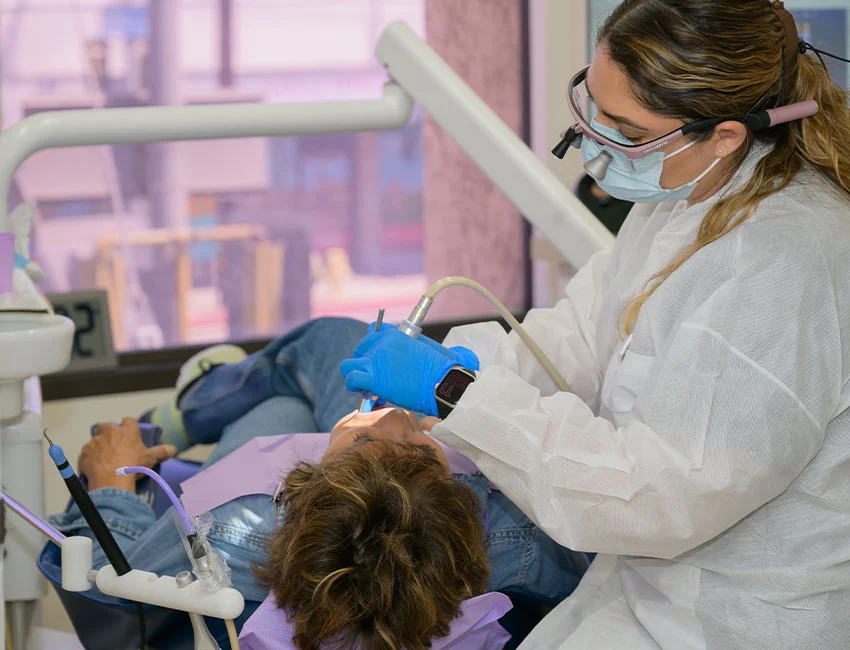 Female caring dentist working on patients smile